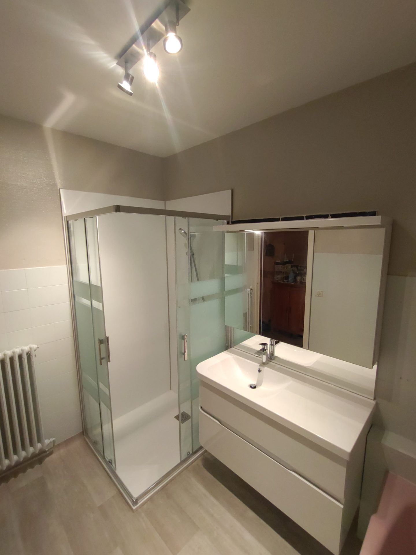 Installation d'un meuble avec vasque moulée intégrée et d'un espace douche, projet de rénovation de salle de bain coordonné par Jimmy Paul sur Lescar.