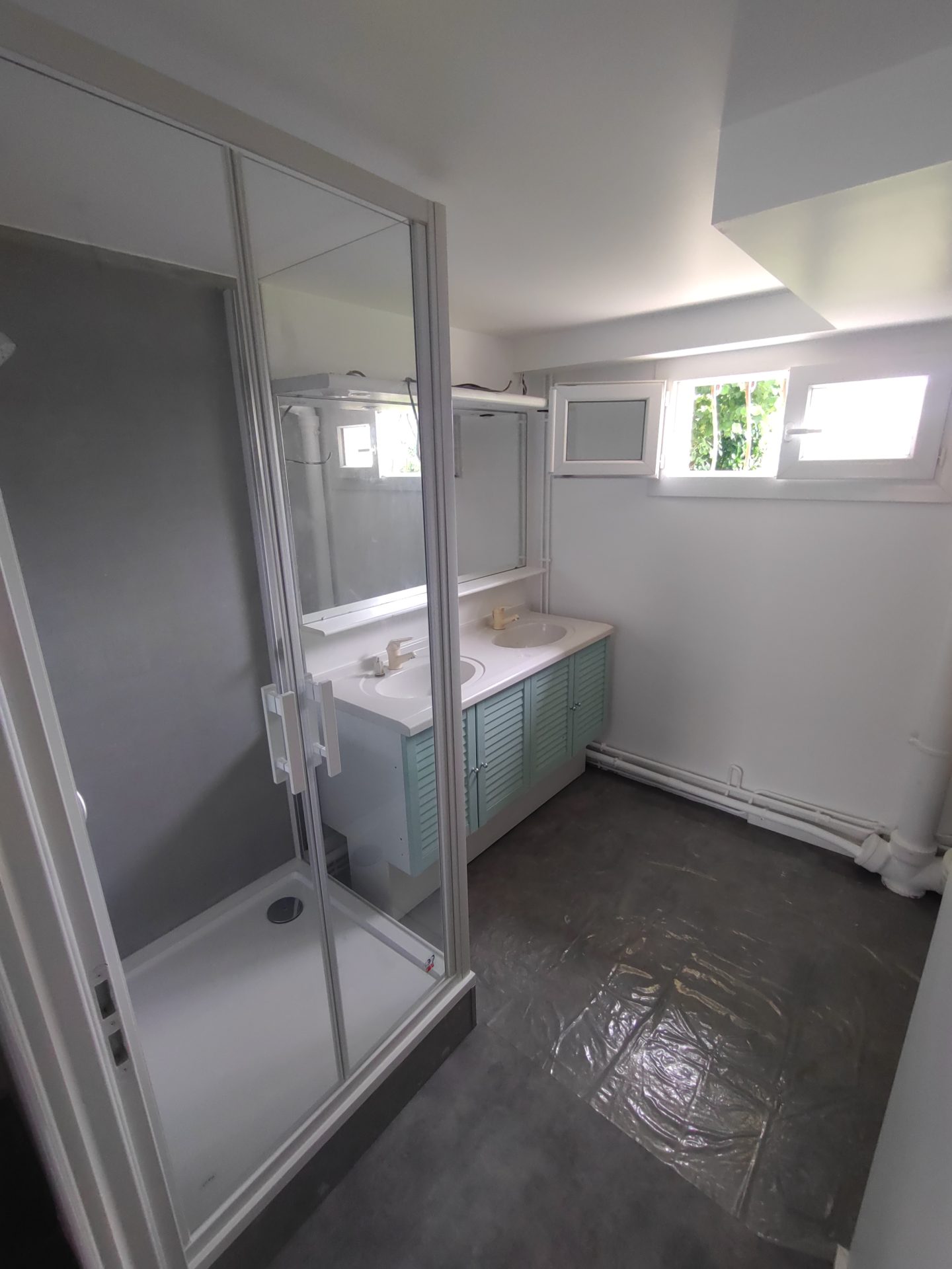 Mise en place d'une cabine de douche fonctionnelle et d'un meuble double vasque lors d'une rénovation de salle de bain par Jimmy Paul à Gelos.